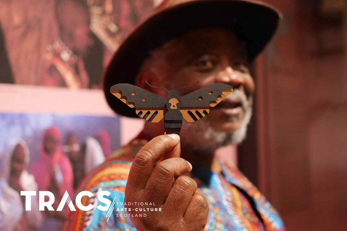 African storyteller holding a delicate paper moth