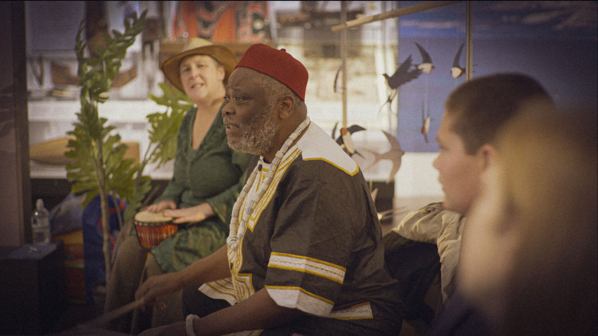 Gift Amu-Logotse leads a drumming circle with participants at the National Museum of Scotland.