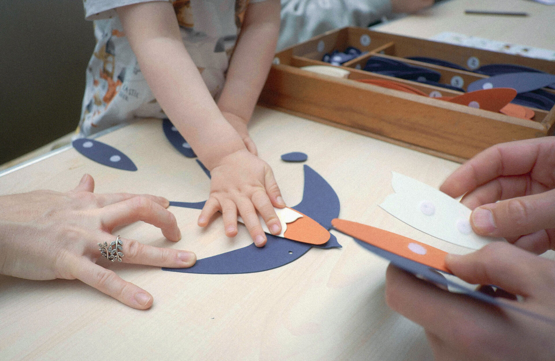 Close up of a child's hands crafting a paper bird.