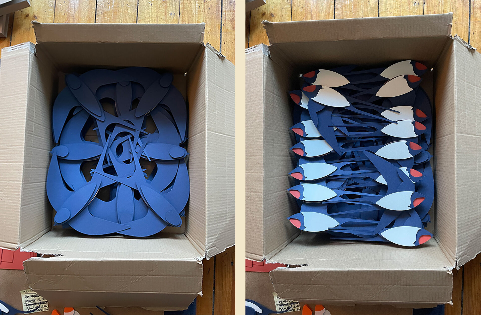 Cardboard boxes containing large-scale paper barn swallows designed for installation in a large gallery space.