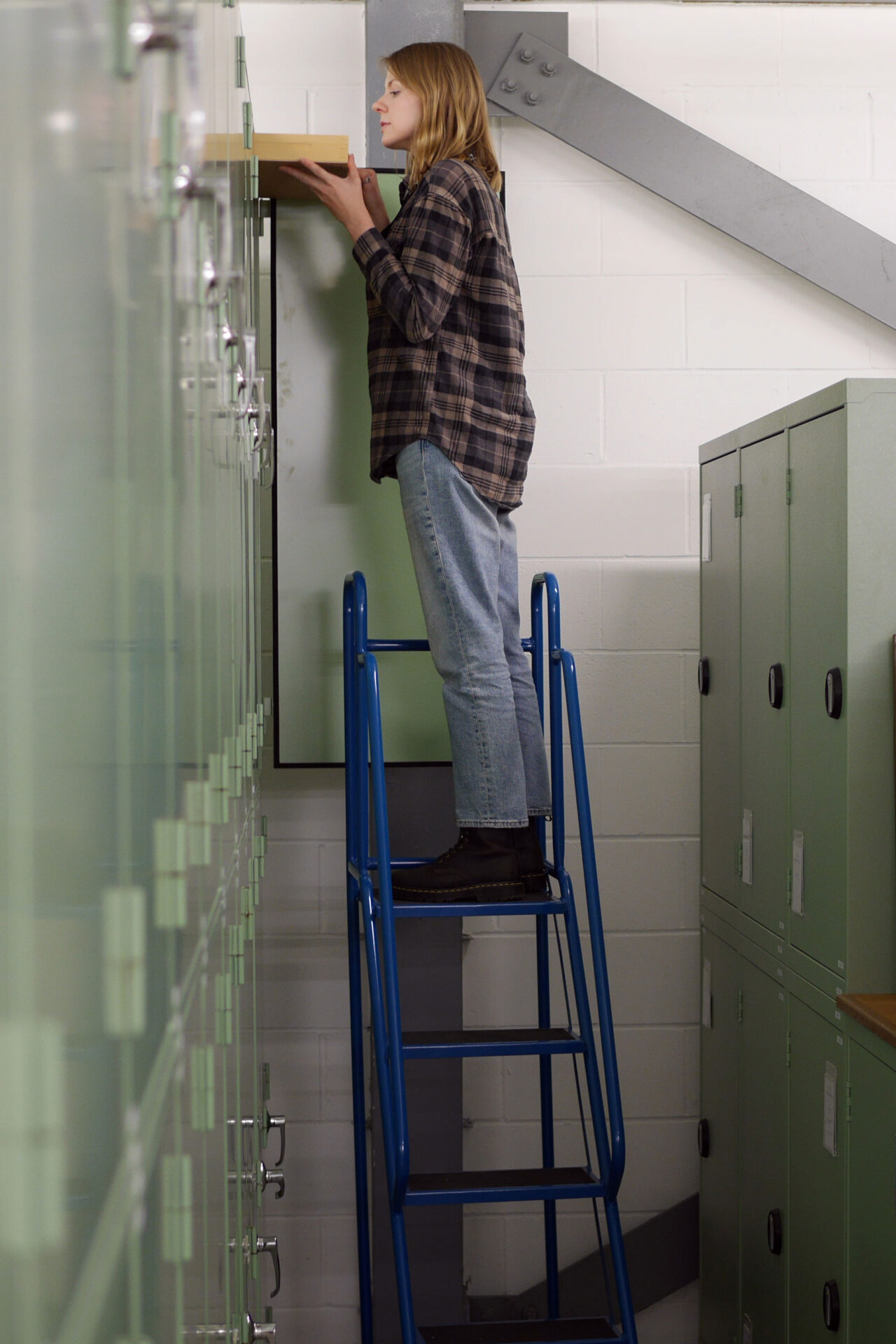 Entomologist Ash Whiffin retrieves a drawer from the very tall insect cabinets.