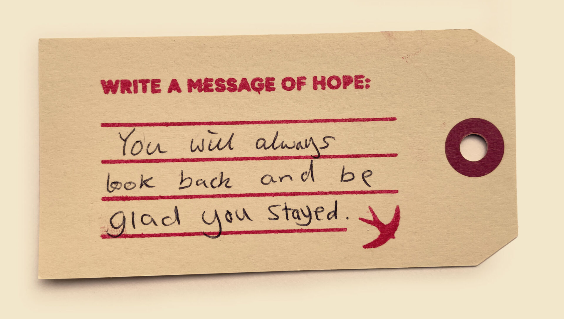 A photo of a luggage label with a handwritten message of hope