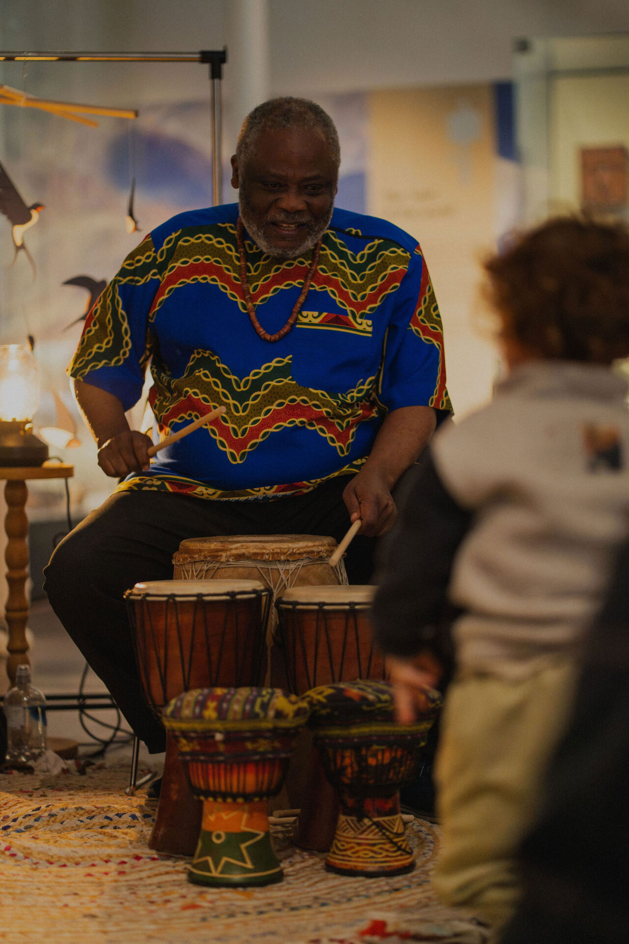 Gift Amu leading children in a participatory song at the National Museum of Scotland.