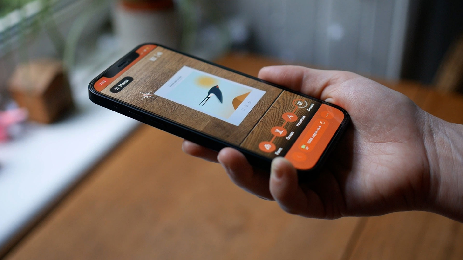 Close-up of a persons hands using a smartphone to explore the Wild Wings of Hope augmented reality postcard.