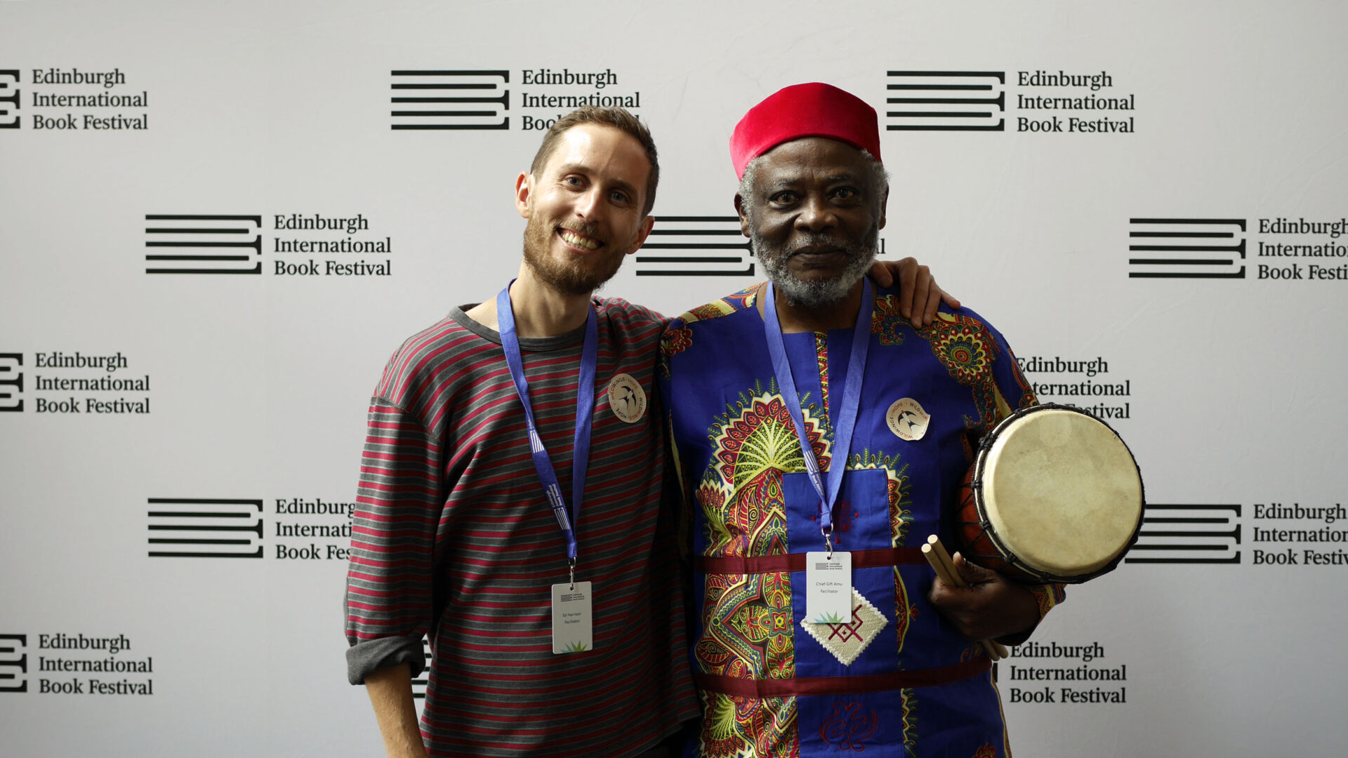 Ed Harrison and Chief Gift Amu-Logotse standing beneath the Edinburgh International Book Festival sign.