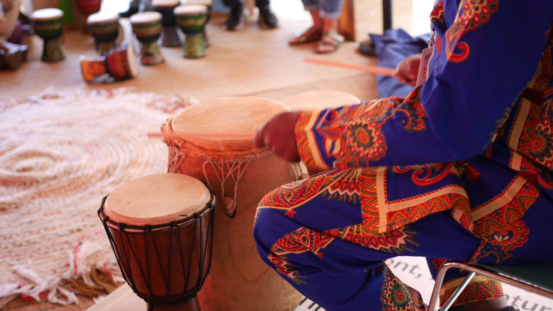 Gift Amu playing traditional African hand drums during the participatory storytelling session.