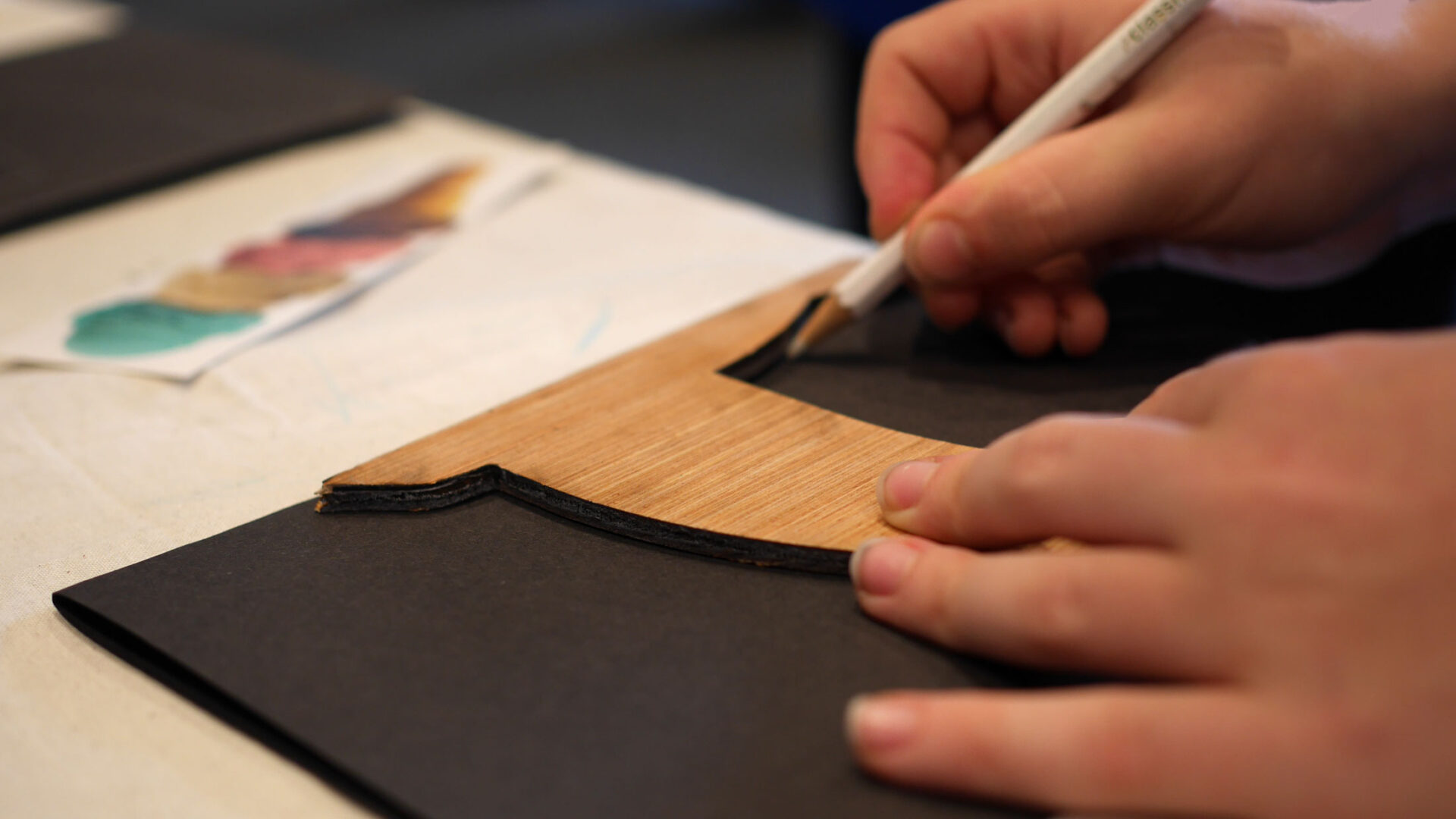 Child tracing a swift stencil onto black card during a Stories of Swifts papercraft workshop at the Edinburgh International Book Festival.